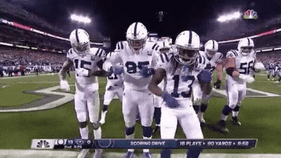 A Group Of Indianapolis Colts Football Players Are Dancing On The Field . GIF