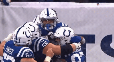 A Group Of Indianapolis Colts Players Are Huddled Together GIF