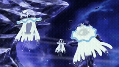 A Group Of Jellyfish Are Swimming In The Ocean Near A Rock . GIF