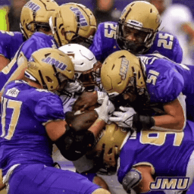 A Group Of Jmu Football Players Are Playing A Game Of Football GIF