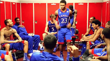 A Group Of Kansas Basketball Players Sitting In A Locker Room GIF