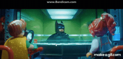 A Group Of Lego Characters Are Looking At Batman Through A Glass GIF