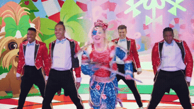A Group Of Men And A Woman Are Dancing In Front Of A Colorful Background GIF