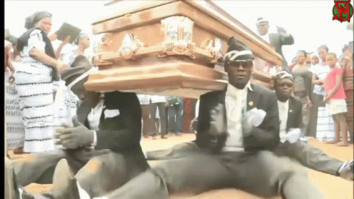 A Group Of Men Are Carrying A Wooden Coffin With A Sign That Says ' R.i.p ' On It GIF