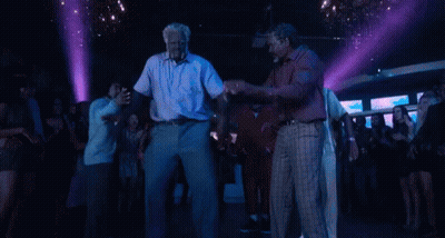 A Group Of Men Are Dancing In A Club With Purple Lights . GIF