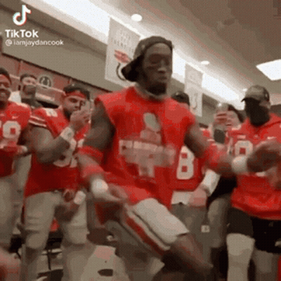 A Group Of Men Are Dancing In A Locker Room . GIF