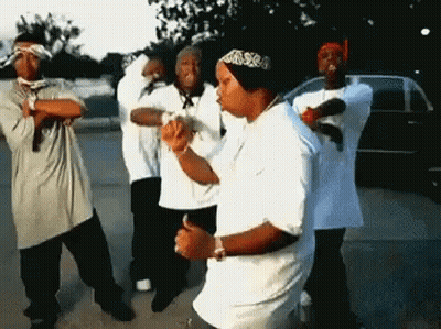 A Group Of Men Are Dancing In A Parking Lot GIF