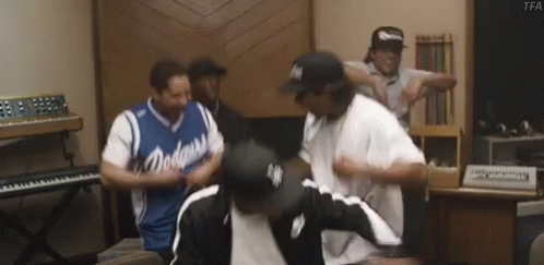A Group Of Men Are Dancing In A Room With A Piano . GIF