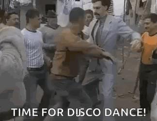 A Group Of Men Are Dancing In A Street With A Man In A Suit And Tie . GIF