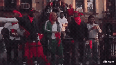 A Group Of Men Are Dancing In Front Of A Building On A City Street . GIF