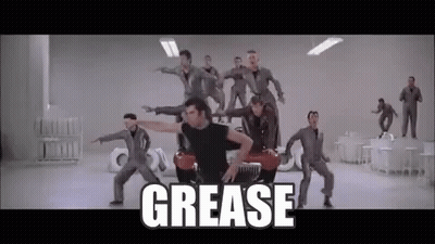 A Group Of Men Are Dancing In Front Of A Car With The Word Grease Written On The Bottom . GIF