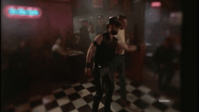 A Group Of Men Are Dancing In Front Of A Neon Sign That Says The Bitter GIF