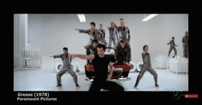 A Group Of Men Are Dancing In Front Of A Red Car And The Words Grease ( 1978 ) Paramount Pictures GIF