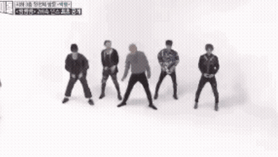 A Group Of Men Are Dancing In Front Of A Sign That Says ' 2 ' GIF
