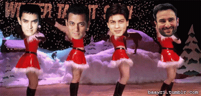 A Group Of Men Are Dancing In Front Of A Sign That Says Christmas GIF