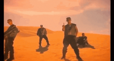A Group Of Men Are Dancing In The Desert . GIF