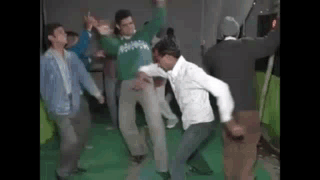 A Group Of Men Are Dancing On A Green Floor . GIF