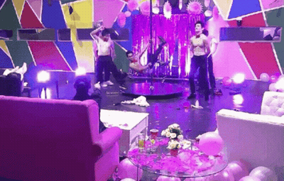 A Group Of Men Are Dancing On A Pole In A Room GIF