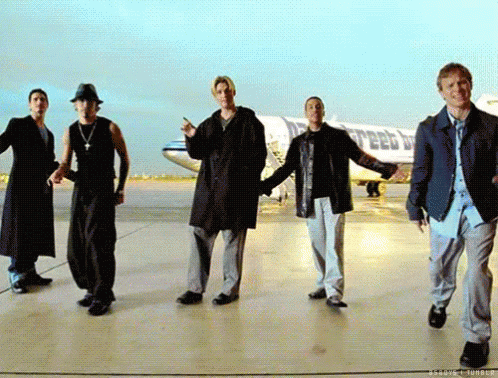 A Group Of Men Are Dancing On A Runway In Front Of A Plane That Says United Airlines GIF