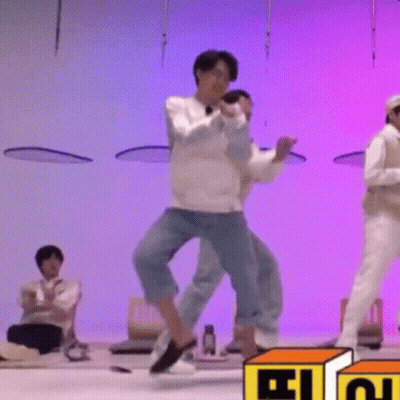 A Group Of Men Are Dancing On A Stage In Front Of A Purple Background . GIF