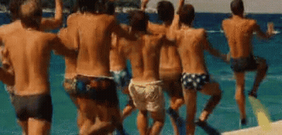 A Group Of Men Are Dancing On The Beach . GIF