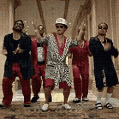 A Group Of Men Are Dancing Together In A Hallway . One Of The Men Is Wearing A Bathrobe . GIF