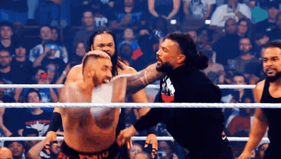 A Group Of Men Are Fighting In A Wrestling Ring . GIF