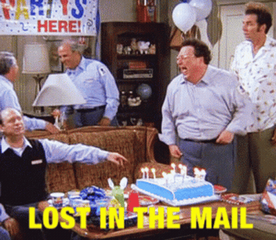A Group Of Men Are Gathered Around A Table With A Birthday Cake And The Words Lost In The Mail GIF