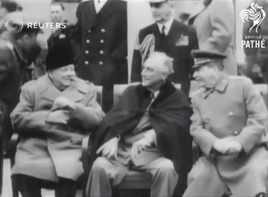 A Group Of Men Are Gathered In Front Of A Sign That Says Pathe GIF