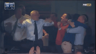 A Group Of Men Are Hugging In A Fox Nfl Stadium GIF