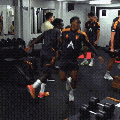 A Group Of Men Are In A Gym Wearing Shirts With The Letter A On The Front GIF