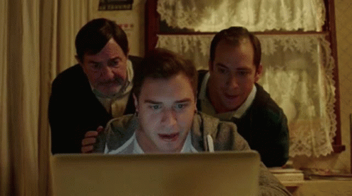 A Group Of Men Are Looking At A Laptop Screen GIF