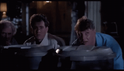 A Group Of Men Are Looking Into Garbage Cans GIF