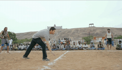 A Group Of Men Are Playing A Game Of Cricket On A Sandy Field GIF