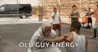 A Group Of Men Are Playing Basketball On A Court With The Words Old Guy Energy Written On The Bottom GIF