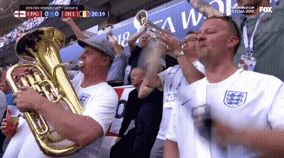 A Group Of Men Are Playing Brass Instruments In A Stadium During A Soccer Game . GIF