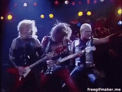 A Group Of Men Are Playing Guitars And Singing On A Stage In Front Of A Crowd . GIF