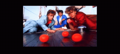 A Group Of Men Are Playing With Red Balls On A Wooden Floor GIF