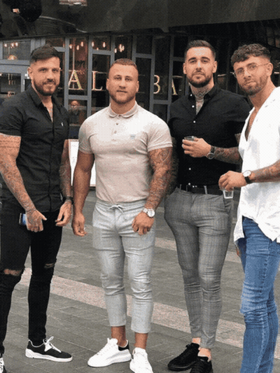 A Group Of Men Are Posing For A Picture In Front Of A Building That Has The Letter A On It GIF
