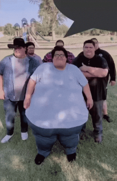 A Group Of Men Are Posing For A Picture With One Of Them Being A Very Large Man GIF