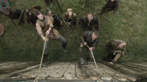 A Group Of Men Are Pulling Ropes Over A Wooden Bridge GIF