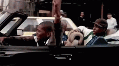 A Group Of Men Are Riding In A Convertible Car And Giving Each Other A High Five . GIF