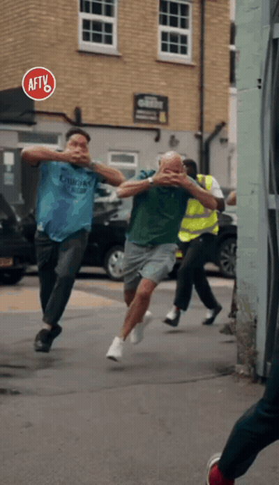 A Group Of Men Are Running Down A Street With A Sign That Says Aft On It GIF