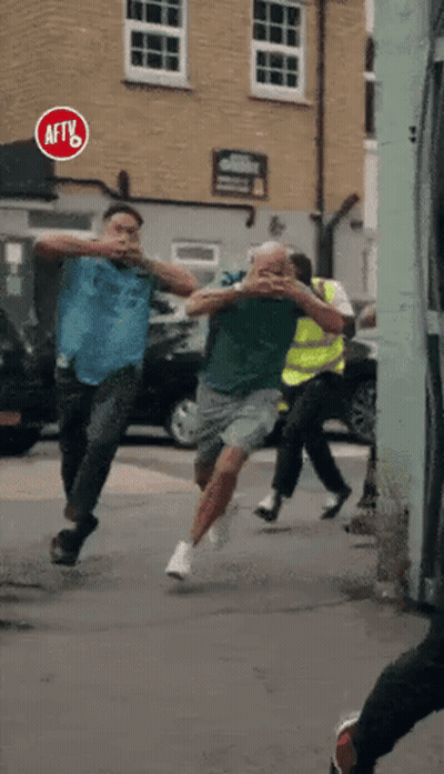 A Group Of Men Are Running Down A Street With A Sign That Says Aftv On It GIF