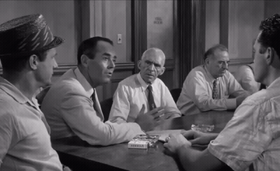 A Group Of Men Are Sitting Around A Table With A Box Of Marlboro Cigarettes In Front Of Them GIF