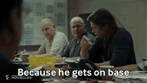 A Group Of Men Are Sitting Around A Table With The Words " Because He Gets On Base " Written On The Screen GIF