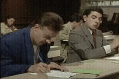 A Group Of Men Are Sitting At A Table Writing On Papers . GIF