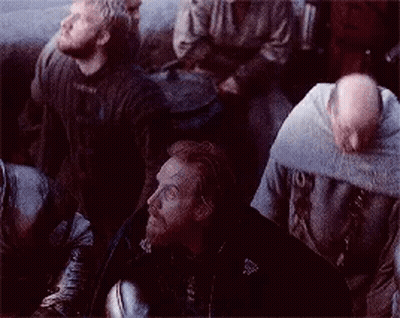 A Group Of Men Are Sitting In A Dark Room Looking Up At Something . GIF