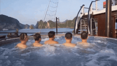 A Group Of Men Are Sitting In A Hot Tub On The Deck Of A Boat GIF