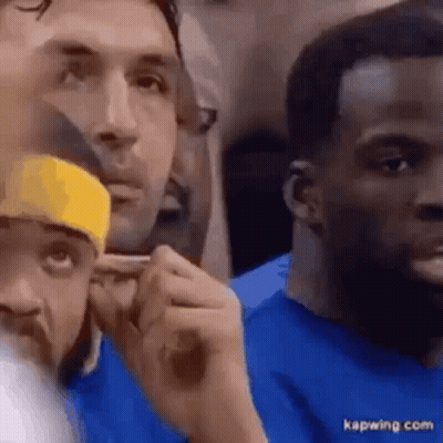 A Group Of Men Are Sitting In A Stadium Watching A Game . GIF